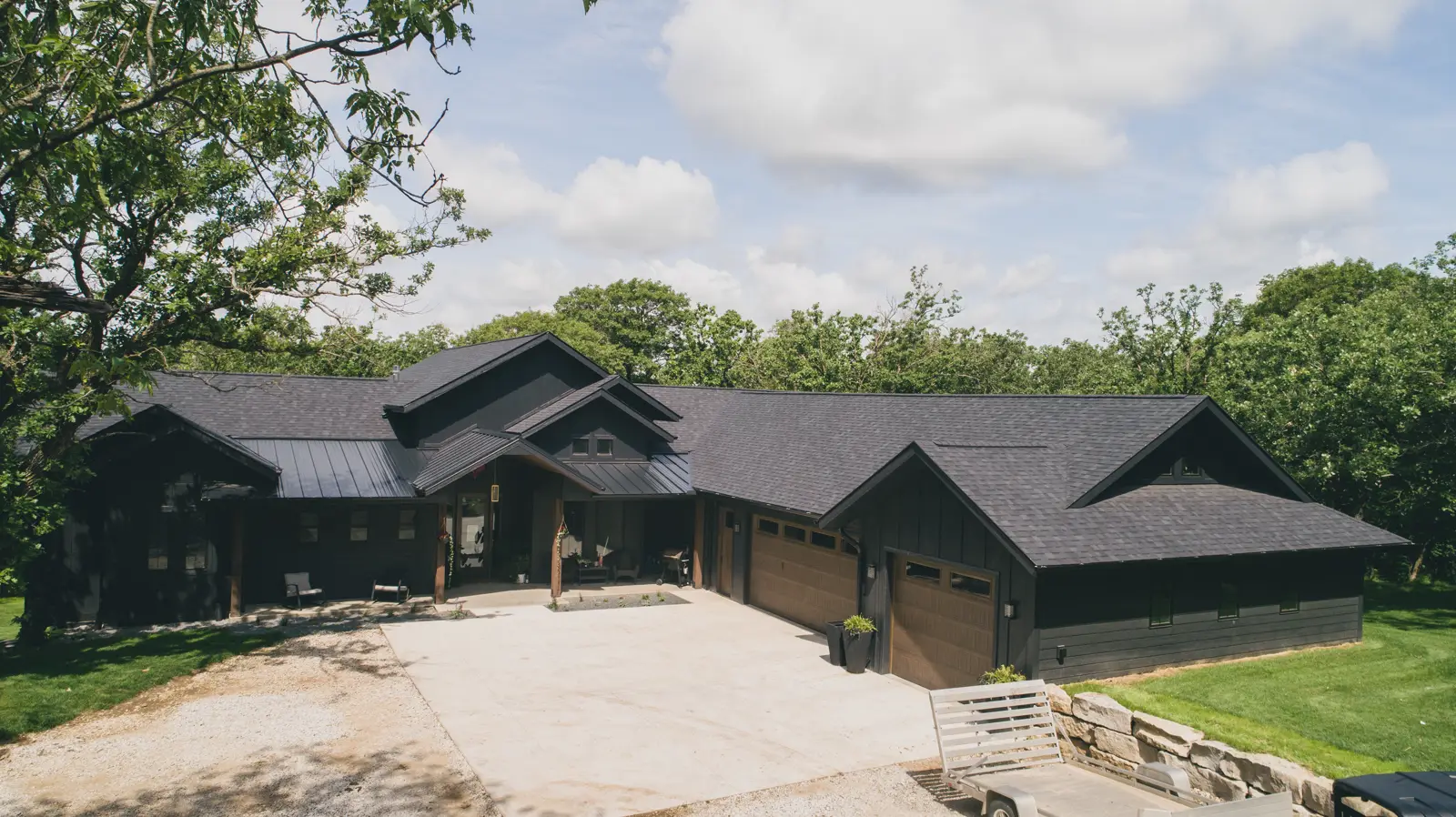 Drone view of a completed dark shingle roof on a timber-accent home